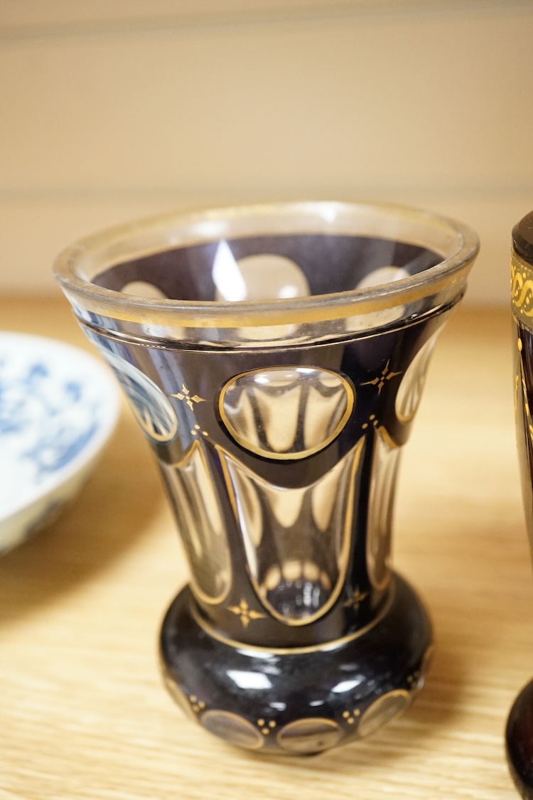 A 19th century Bohemian engraved ruby glass goblet, a similar amethyst and clear overlaid glass vase and an enamelled amethyst glass goblet, largest 15cm high